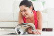 Foto: Woman lying on floor looking at catalog Woman lying on floor looking at catalog