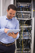 Foto: Man in data centre with tablet pc Man in data centre with tablet pc