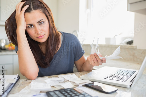 Photo: Young woman looking worried over finances Young woman looking worried over finances