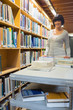 Smiling librarian pushing book trolley