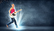 young woman playing on electro guitar and jumping