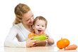 Mother with baby  baby at table. Boy holding zucchini