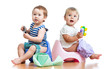 babies toddlers sitting on chamber pot and playing with toys