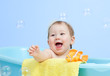 adorable baby taking bath in blue tub