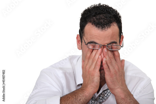 Photo: Tired worker rubbing his eyes Tired worker rubbing his eyes