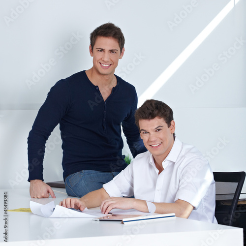 Photo: Mitarbeiter sitzen im Büro Mitarbeiter sitzen im Büro