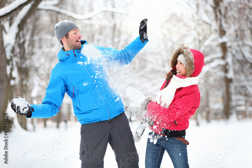 Photo: Young couple in snowball fight Young couple in snowball fight