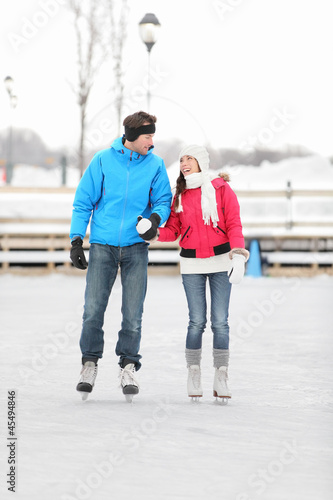 Photo: Young couple ice skating outdoors Young couple ice skating outdoors