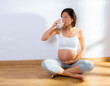 Beautiful pregnant woman drinking milk at home