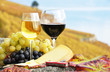 Two wineglasses, cheese and grapes on the terrace of vineyard in