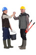 Construction co-workers gripping hands