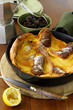 Dutch baby pancake served whole in a cast-iron skillet