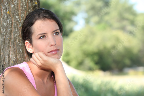 Photo: Pensive woman with tree trunk Pensive woman with tree trunk