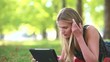 Young woman with tablet computer on grass