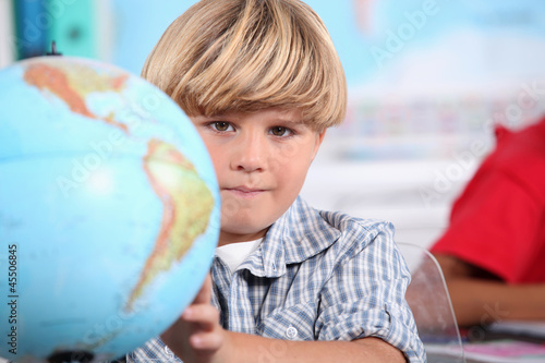 Photo: Kid learning geography. Kid learning geography.