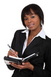 An African American businesswoman with a planner.