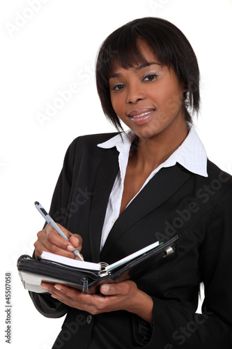 Photo: An African American businesswoman with a planner. An African American businesswoman with a planner.