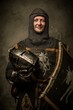 Smiling medieval knight  holding helmet