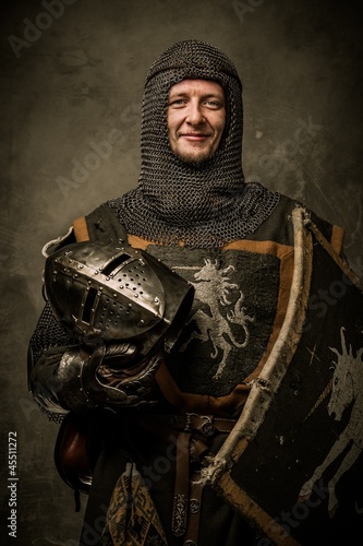 Photo: Smiling medieval knight holding helmet Smiling medieval knight holding helmet