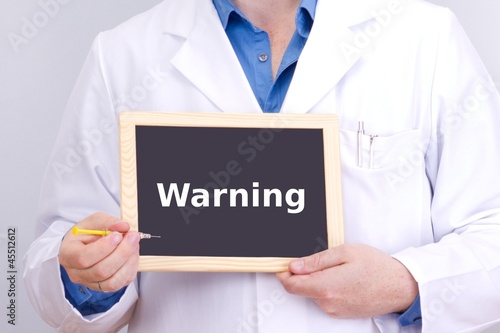 Photo: Doctor shows information on blackboard: warning Doctor shows information on blackboard: warning