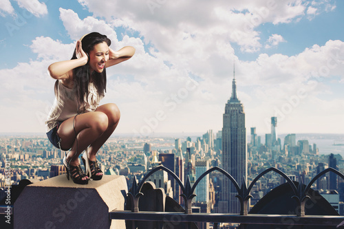 Photo: Beautiful girl listening to music standing on the rooftop Beautiful girl listening to music standing on the rooftop