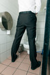 Ein Mann steht in der Toilette und pinkelt