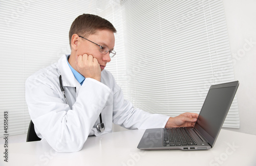 Photo: doctor using his laptop computer doctor using his laptop computer