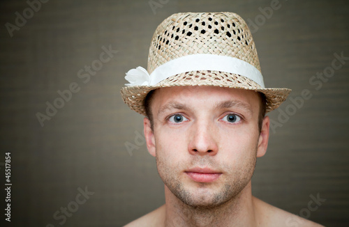 Photo: Young man in a fun straw hat Young man in a fun straw hat