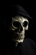 Hooded scary skeleton on black background