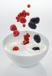 Berries falling into a bowl of yogurt