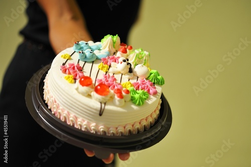 Photo: A woman holding a birthday cake A woman holding a birthday cake