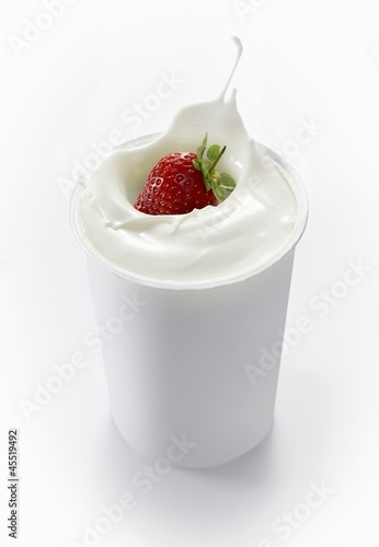 Photo: A strawberry falling into a cup of yogurt A strawberry falling into a cup of yogurt