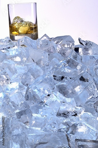 Photo: A whiskey glass on a mountain of ice cubes A whiskey glass on a mountain of ice cubes