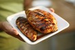 Woman Holding a Platter with Three Grilled Chicken Breasts