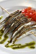 Grilled sardines on a skewer with pesto and tomato salad