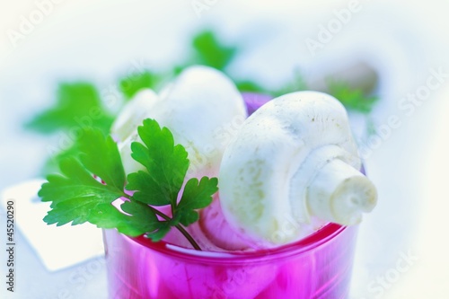 Photo: Fresh mushrooms and parsley in a pink glass Fresh mushrooms and parsley in a pink glass