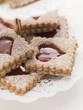 Jam biscuits with icing sugar on a cake stand