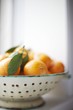 Clementines in a White Colander on a Window Sill