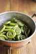 Colander of Fiddleheads on a Wooden Table