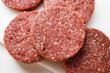 Raw burgers on chopping board