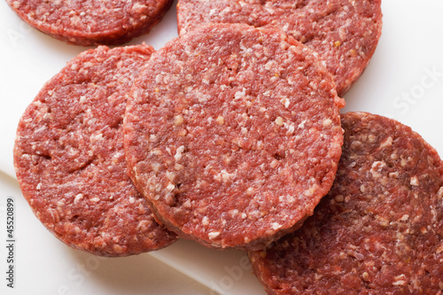 Photo: Raw burgers on chopping board Raw burgers on chopping board