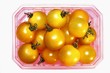 Foto: Yellow cherry tomatoes in a plastic punnet Yellow cherry tomatoes in a plastic punnet