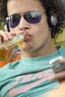Youth drinking beer and listening to music