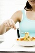 Eating spaghetti with herbs and vegetables