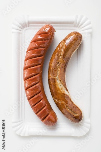Photo: White and red sausages on a paper plate White and red sausages on a paper plate