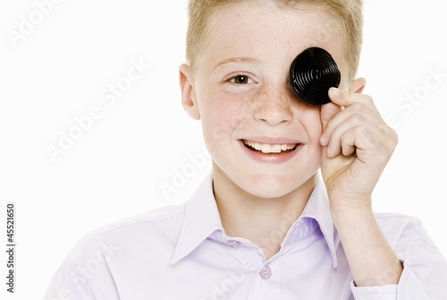 Photo: Boy covering one eye with a liquorice wheel Boy covering one eye with a liquorice wheel