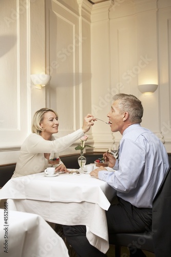 Photo: Mature couple enjoying dessert in a restaurant Mature couple enjoying dessert in a restaurant