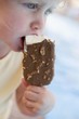 Small girl eating an ice cream on a stick
