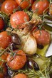 Fried cherry tomatoes with garlic and olives (close-up)