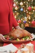 Woman serving roast duck (Christmas)